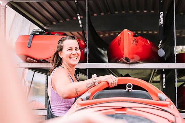 Happy KAYAKOMAT operator helping a customer return their rental kayak to the automatic kayak rental station.